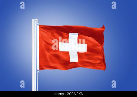 Flagge der Schweiz, die gegen einen blauen Himmel fliegt Stockfoto