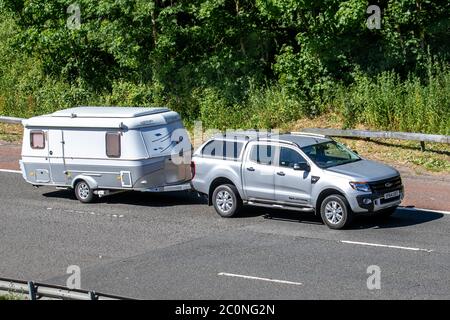 Ford Wildtrak Doppelkabine Pickup Schleppen ERIBA Touring GT Kult Caravan. Reisemobile, Campingbusse, Wohnmobil, Familienurlaub, Urlaub in deutschen Caravanetten, Urlaub in Wohnwagen, Leben auf der Straße. Fahrzeugverkehr Fahrzeuge bewegen, SUV-Autos fahren Fahrzeug auf britischen Straßen, Motoren, Autofahren auf der Autobahn M6 Stockfoto