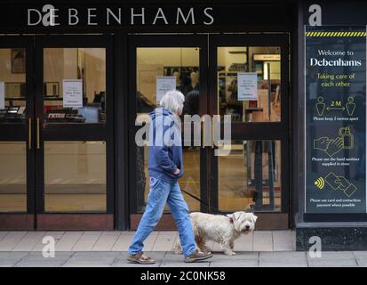 Winchester, Hampshire. Juni 2020. Geschäfte in Winchester bereiten sich darauf vor, am Montag, 15., nach der Coronavirus-Sperre wieder zu öffnen. Eine Frau und ihr Hund vor der Sicherheitsbeschilderung in Debenhams. Credit Stuart Martin/Alamy Live News Stockfoto