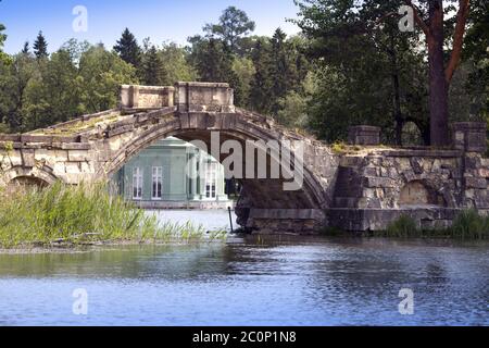 Die altertümliche zerstörte Brücke im Park und dem Pavillon V Stockfoto