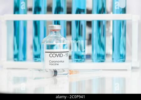 Flasche Coronavirus-Impfstoff und Spritze auf weißem Tisch. Forschungs- und Entwicklungskonzept des Wissenschaftslabors. Stockfoto