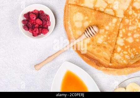 Pfannkuchen mit Beeren und Honig zum Frühstück auf weißem rustikalen Tisch Stockfoto