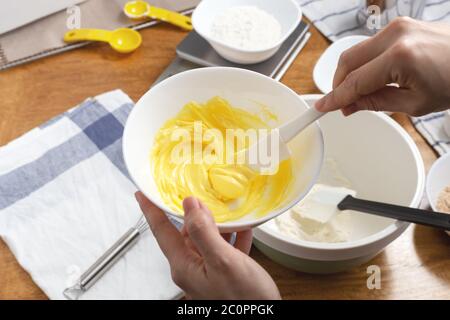 Butter in Schüssel mit Spatel in der Hand mit Zutaten zum Backen Cookie mischen Stockfoto