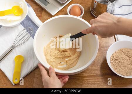 Handhalten Spatel Zutaten mischen in Schüssel zum Backen von Cookies Stockfoto