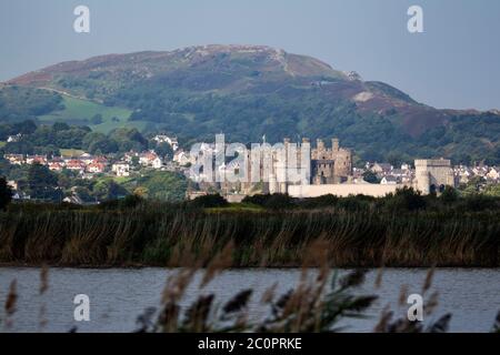 Conwy Castle, röhrenförmige Eisenbahnbrücke und Stadt Blick nach Westen von der anderen Seite des Flusses Conwy mit dem Sychnant Pass im Hintergrund Stockfoto