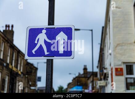 Ein blau-weißes Fußgängerschild, das an einem Pfosten während Covid-19 angebracht ist. Das Schild fordert die Leute auf, in Baildon, Yorkshire, in die gleiche Richtung zu gehen. Stockfoto