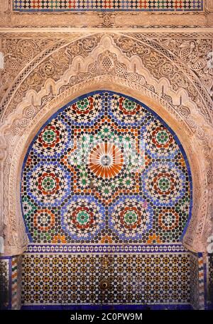 Fez, Marokko. Detail des historischen Brunnens in der Medina UNESCO-Stätte. Farbenfrohe islamische Gestaltung, glasierte Keramikfliesen und komplizierte Alabasterarbeiten. Stockfoto