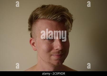 Junger Mann in seiner Mitte-20er Jahre mit Shaved Side Frisur lächelnd an der Kamera Stockfoto