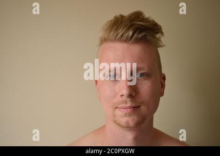 Junger Mann mit Rasierte Seiten Frisur lächelnd an die Kamera Stockfoto