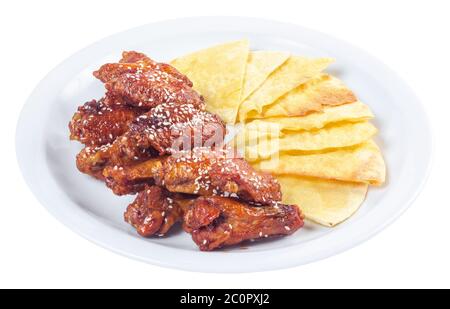 Chicken Wings in würziger Sauce. Beliebte Pub Gericht. Schöne Junk-Food-Konzept. Isoliert auf einem weißen Teller. Stockfoto