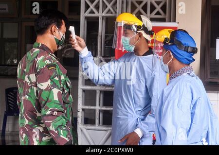 Sleman, YOGYAKARTA, INDONESIEN. Juni 2020. Das Gesundheitspersonal misst die Temperatur der Krankenhausbesucher, indem es sich mit einem Feldschild vor dem Ausbruch des Corona-Virus in Sleman, Yogyakarta, am Freitag, 12. Juni 2020, schützt. Die indonesische Regierung bestätigte, dass sie auf 1,111 Fälle auf 36,406 Coronavirus-positive Fälle anstieg. Quelle: Slamet Riyadi/ZUMA Wire/Alamy Live News Stockfoto