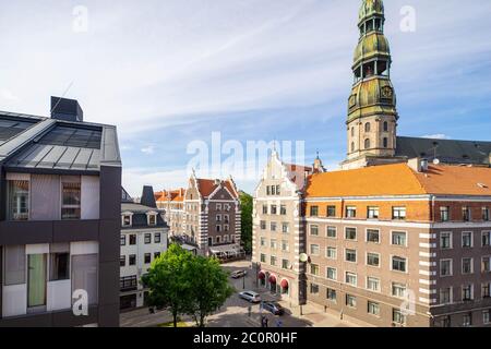 Sonniger Tag in der Altstadt von Riga Lettland. Ein Äußeres von moderner und traditioneller Architektur. Rote Ziegeldächer. St. Peter's Church. Stockfoto