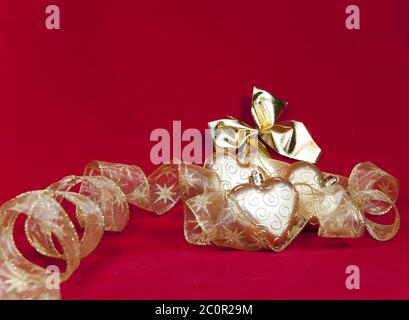 goldene Weihnachtsdekorationen auf rotem Hintergrund Stockfoto