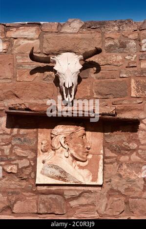 Kuhschädel und Schnitzerei des Navajo-Mannes über dem Ladeneingang in der Hubbell Trading Post National Historic Site, Navajo Indian Reservation, Ganado, Arizona USA Stockfoto