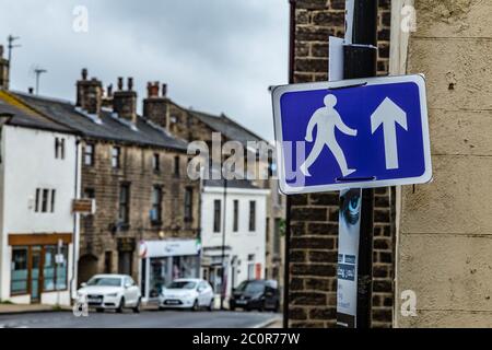 Ein blau-weißes Fußgängerschild, das an einem Pfosten während Covid-19 angebracht ist. Das Schild fordert die Leute auf, in Baildon, Yorkshire, in die gleiche Richtung zu gehen. Stockfoto