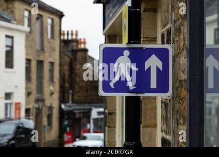 Ein blau-weißes Fußgängerschild, das an einem Pfosten während Covid-19 angebracht ist. Das Schild fordert die Leute auf, in Baildon, Yorkshire, in die gleiche Richtung zu gehen. Stockfoto