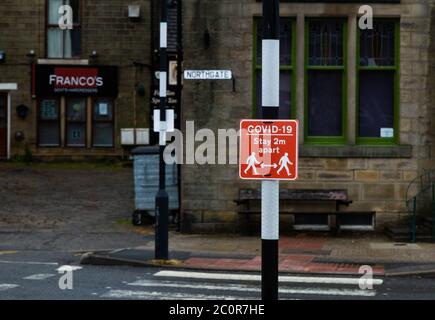 Covid-19 Schilder in Baildon, Yorkshire, warnen die Menschen zu Fuß 2 Meter auseinander. Stockfoto