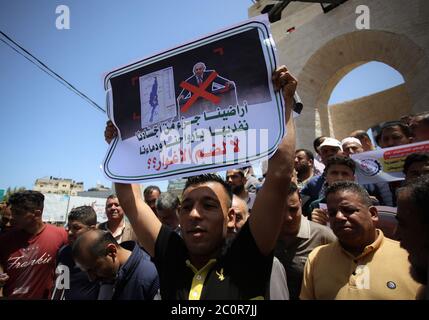 Rafah, Palästina. Juni 2020. Ein Mann zeigt während des Protestes ein Plakat. Palästinenser protestieren gegen Israels Pläne, Teile des besetzten Westjordanlandes in Rafah im südlichen Gazastreifen zu annektieren. Juni 11, 2020. Die Pläne sehen vor, Siedlungen im Westjordanland und das Jordantal, wie vom US-Präsidenten vorgeschlagen, anzugliedern. (Foto von Yousef Masoud/INA Photo Agency/Sipa USA) Quelle: SIPA USA/Alamy Live News Stockfoto