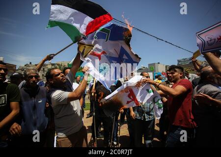 Rafah, Palästina. Juni 2020. Während der Proteste werden Demonstranten gesehen, wie sie die Plakate verbrennen. Palästinenser protestieren gegen Israels Pläne, Teile des besetzten Westjordanlandes in Rafah im südlichen Gazastreifen zu annektieren. Juni 11, 2020. Die Pläne sehen vor, Siedlungen im Westjordanland und das Jordantal, wie vom US-Präsidenten vorgeschlagen, anzugliedern. (Foto von Yousef Masoud/INA Photo Agency/Sipa USA) Quelle: SIPA USA/Alamy Live News Stockfoto