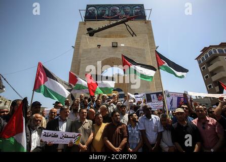 Rafah, Palästina. Juni 2020. Während des Protestes zeigen Palästinenser Plakate und Fahnen. Palästinenser protestieren gegen Israels Pläne, Teile des besetzten Westjordanlandes in Rafah im südlichen Gazastreifen zu annektieren. Juni 11, 2020. Die Pläne sehen vor, Siedlungen im Westjordanland und das Jordantal, wie vom US-Präsidenten vorgeschlagen, anzugliedern. (Foto von Yousef Masoud/INA Photo Agency/Sipa USA) Quelle: SIPA USA/Alamy Live News Stockfoto