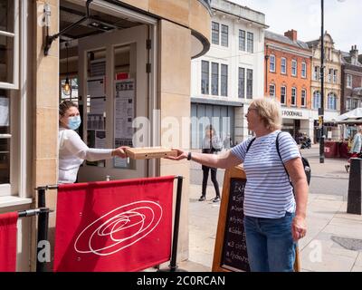 Cambridge, Großbritannien. Juni 2020. Eine Frau kauft eine Pizza zum Mitnehmen im Stadtzentrum, während die Stadt sich für die Wiedereröffnung von nicht wichtigen Geschäften in England am Montag, 15. Juni vorbereitet, da die Sperrung des Coronavirus weiter gelockert wird. Kredit: Julian Eales/Alamy Live Nachrichten Stockfoto