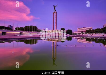 Irian Jaya Liberation Monument, Jakarta im Sonnenuntergang mit Spiegelung des wolkigen Himmels auf dem Wasser Stockfoto