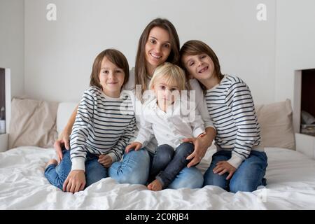 Glückliche Mutter und ihre Kinder auf einem Bett liegend Stockfoto