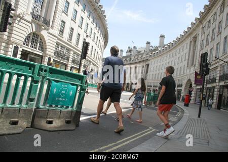 London, Großbritannien. Juni 2020. Eine Familie, die die Regent Street durch Social Distancing Signage und Barrikaden überquerte.einige nicht-wesentliche Geschäfte wie Autohäuser und Outdoor-Märkte in Großbritannien am 1. Juni konnten nach ihrer COVID-19-Schließung in einer Lockerung der Coronavirus-Sperrmaßnahmen wieder öffnen. Kredit: SOPA Images Limited/Alamy Live Nachrichten Stockfoto