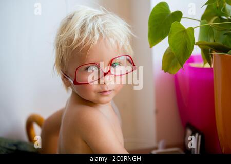 Süßes Kleinkind Junge mit roten Brillen auf weißem Hintergrund, so dass süße Gesichter Stockfoto