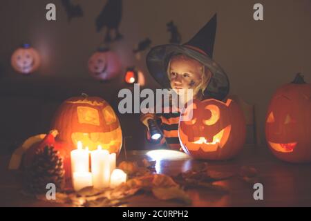 Liebenswert Kind, Kleinkind Mädchen, spielen mit Halloween geschnitzten Kürbis und Dekoration zu Hause Stockfoto