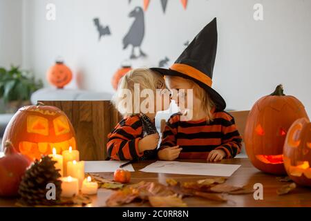 Liebenswert Kinder, Kleinkind Junge und Mädchen, spielen mit Halloween geschnitzten Kürbis, küssen freundlich Stockfoto