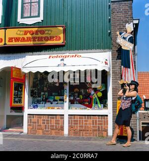 Volendam, Holland-August 08,2019: Japanischer Tourist, der vor photoshop fotografiert und ein Foto aus Pappe von Mädchen im Volendam Kostüm in Volendam, Holl Stockfoto