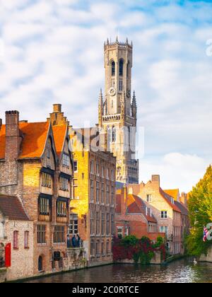 Glockenturm und Ziegelhäuser am Wasserkanal, Brügge, Belgien. HDR-Bild. Stockfoto