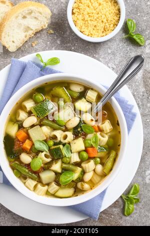 Frische hausgemachte Gemüsesuppe aus Zucchini, Sellerie, Karotten, Erbsen, weißen Bohnen, grünen Bohnen, Kartoffeln, Tomaten, Spinat und Ditali Suppe Pasta, garnieren Stockfoto