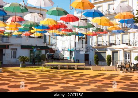 Andalusien in Spanien: Eine Kunstinstallation mit bunten Schirmen auf der Plaza de la Constitución, Torrox Pueblo Stockfoto