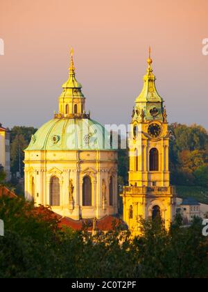 Beleuchtete Kuppel und Turm der St. Nikolaus-Kirche in der Kleinseite von Prag - Hauptstadt der Tschechischen republik, Europa. Abendaufnahme bei Sonnenuntergang. UNESCO-Weltkulturerbe Stockfoto