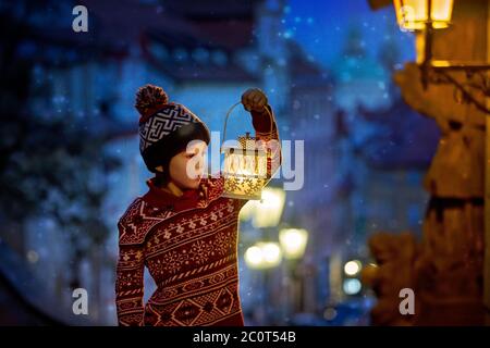 Schöne Vorschulkind, mit Laterne, lässig gekleidet, Blick auf Nacht Blick auf Prag Stadt, Winter Stockfoto