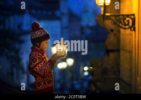 Schöne Vorschulkind, mit Laterne, lässig gekleidet, Blick auf Nacht Blick auf Prag Stadt, Winter Stockfoto