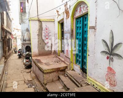 Varanasi, Uttar Pradesh, Indien - Februar 2015: Die hellblaue Tür eines alten Hauses in einer engen gepflasterten Gasse in der Stadt. Stockfoto