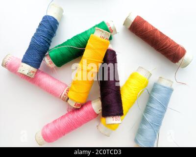 Buntes Garn auf Spulenrohr Gewinde isoliertes Bild auf weißem Hintergrund. Stockfoto
