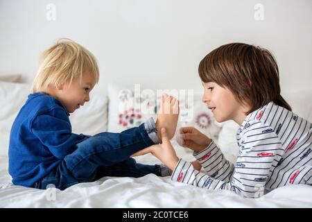 Kinder, Brüder, spielen zu Hause, kitzeln Füße lachen und lächeln Stockfoto
