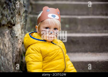 Liebenswert blonde Kleinkind Kind mit Bär Maske und bemalten Gesicht, lächelnd Stockfoto