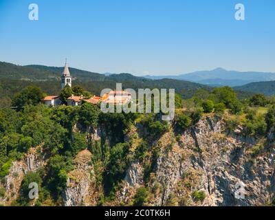 Blick auf die tiefe Schlucht des Flusses Reka und Dorf mit ländlichen Kirche, Skocjan Höhlen, Slowenien Stockfoto