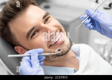 Mann, der Zähne Zahnärzte untersucht. Übersicht von Karies Vorbeugung Stockfoto