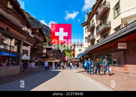 ZERMATT, SCHWEIZ - 15. JULI 2019: Traditionelle Häuser im Zentrum von Zermatt im Kanton Wallis in der Schweiz Stockfoto