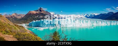 Panoramablick auf den gigantischen Perito Moreno Gletscher, seine Zunge und Lagune in Patagonien im goldenen Herbst, Argentinien, sonniger Tag, blauer Himmel Stockfoto