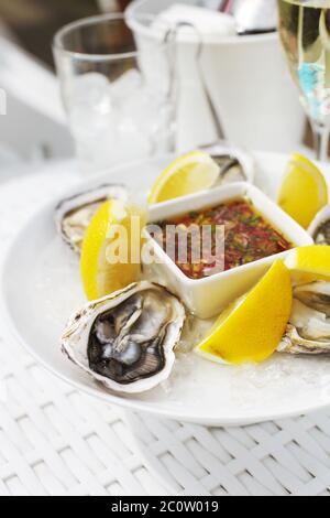 Frische Austern Schale mit Zitrone und Gläser Champagner. Draufsicht Stockfoto