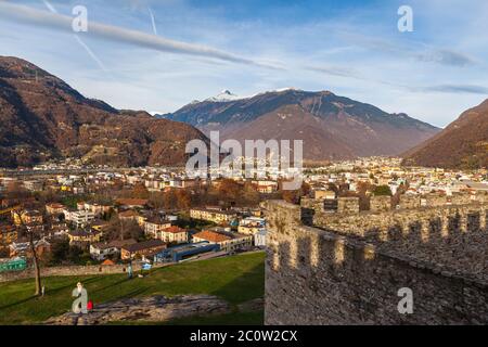 Atemberaubende Luftpanoramabsicht von Bellinzona Stadtbild in schönem Sonnenlicht von Schloss Castelgrande mit Schweizer Alpen und blauer Himmelswolke im Hintergrund, Stockfoto