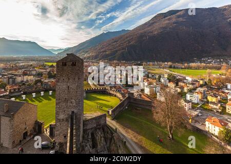 Atemberaubende Luftpanorama von Bellinzona Stadt von oben auf der Burgruine Castelgrande mit herrlichem Sonnenschein, Schweizer Alpen mit blauer Himmelswolke im Hintergrund Stockfoto