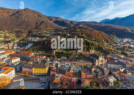 Atemberaubende Luftpanoramabsicht der Altstadt von Bellinzona mit Schloss Montebello Schloss Sasso Corbaro und Schweizer Alpen mit blauer Himmelswolke im Hintergrund, auf Stockfoto